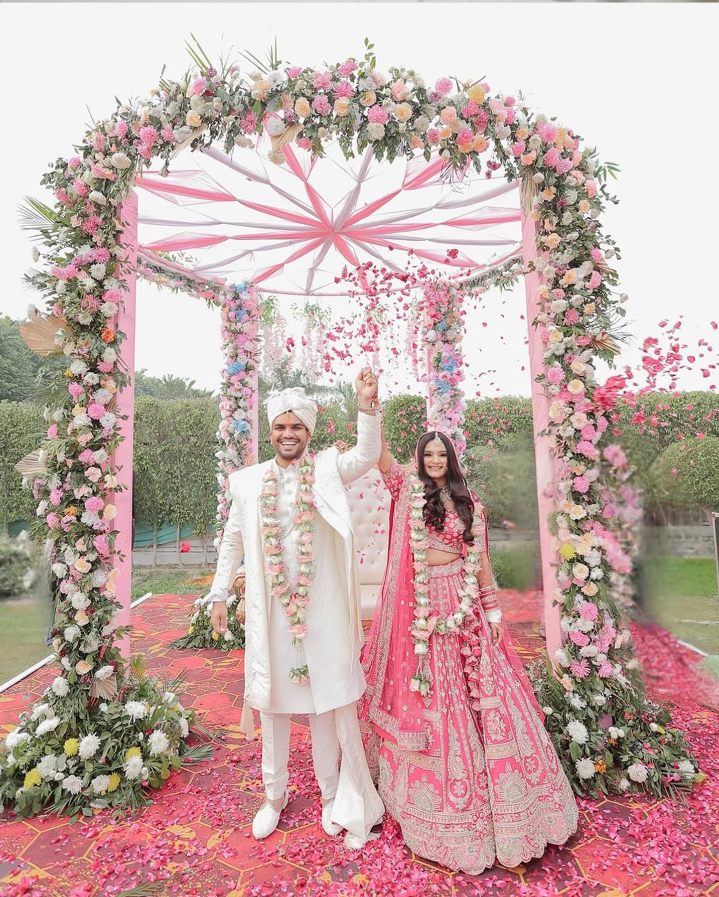 Couple under pink floral mandap